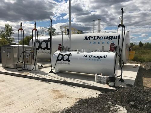 Shows outdoor shot of large white tank with Mcdougall Energy logo on it and BCT logo