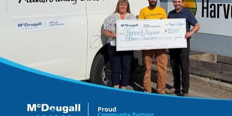 Three people holding a large cheque for 15,000 dollars